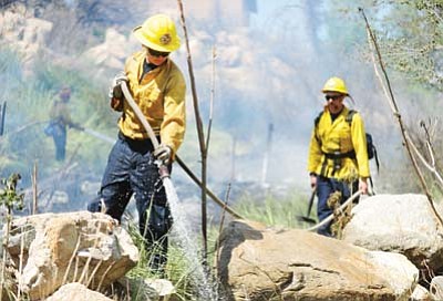 City of Prescott firefighters extinguish hotspots in a small wildland fire in 2014 in downtown Prescott. City officials are seeing the police and fire pension sales tax efforts paying off; rather, paying down the unfunded-liability debt to the extent that the city may be able to retire the dedicated sales tax years early. (Courier file)