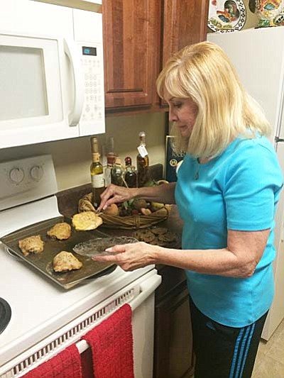 Sharon Egan cooks chicken and vegetables in her kitchen. Egan cannot eat wheat products but she has learned how to prepare flavorful, appealing meals that benefit her health. (Tribune photo/Briana Lonas)