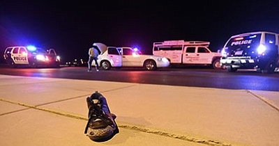 Prescott Valley Police Officer Matthew Cahill an accident reconstructionist inspects a crosswalk where a 20-year-old man was hit and pinned by a car, left, Friday night April 1, 2016 at the intersection of Lake Valley Rd. and Lakeshore Dr. in Prescott Valley. (Matt Hinshaw/PNI)