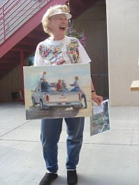 Painter Judith Richter with a painting she produced during the June Second Saturday Art Walk in Old Town at Wind Dancer Gallery.