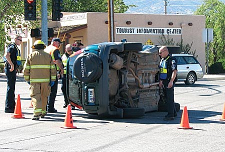 VVN/Jon Hutchinson
Police and fire officials tend to this 2001 Honda CR-V SUV that turned over on its side in the middle of the intersection near the Giant gas station Monday.