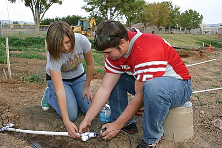 MUHS ag students (right) hook up a section of the flood irrigation system they have designed and are building in the department’s new outdoor lab.