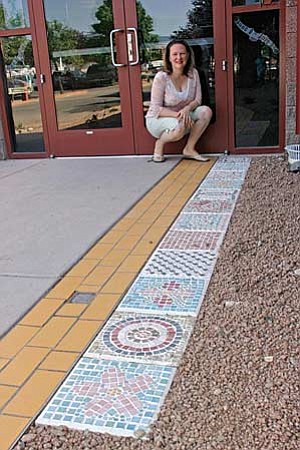 VVN/Philip Wright
Melissa "Max" Moulton posed Friday morning with the mosaic tile steppingstones that sixth-grade English Language Learners at Cottonwood Middle School recently designed and made.