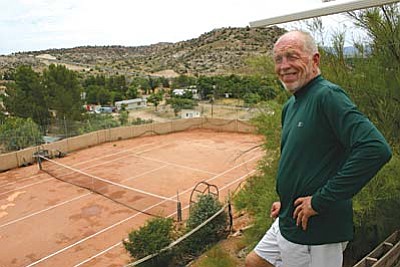 Rick Champion looks over his clay tennis court from a terrace outside of his Cottonwood home. Champion built the home and the tennis court himself.