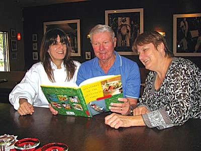 Three heads are better than one. Michelle Moore, owner of Marketplace Café, author Hugh Scott and Canyon Moon Theatre director and producer Mary Guaraldi, peruse a Vietnamese cookbook in preparation for “An Intriguing Evening Through Viet Nam” event