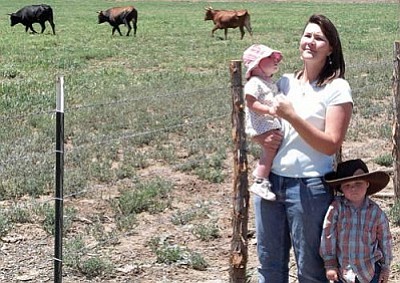 VVN/Mark Duncan<br>
Kacie Tomerlin of Arizona Legacy Beef shows off her kids, Emilia Claire and Cort, while a few of her Criollo cattle graze in the pasture behind.