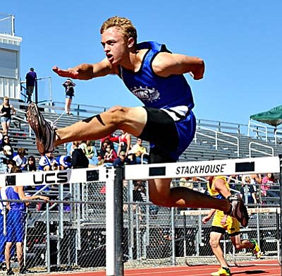 <b>Trent Fogelson</b> leaps over a hurdle during the last track season. VVN/Sean Morris