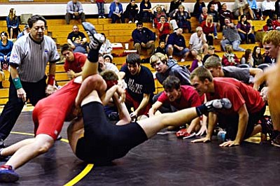 Marauders freshman <b>Wyatt Midkiff</b> tries to pin a Bulldog wrestler close to the mat boundary as his teammates cheer him on at Barry Goldwater HS Wednesday. VVN/Sean Morris
