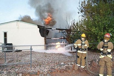 Photos courtesy Robert Church/VVFD<br>
Crews from the Verde Valley Fire District and the Cottonwood Fire Department fight to contain a fire at a home on Cochise Drive in the Verde Villages on Friday evening.