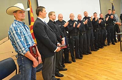 Cory Brady, Eric Fields, and Cole Taylor, far left to right, join the eight police officers at a recognition ceremony Wednesday after the three men were given awards for helping police officers in a brawl at the Cottonwood Walmart recently. VVN/Vyto Starinskas