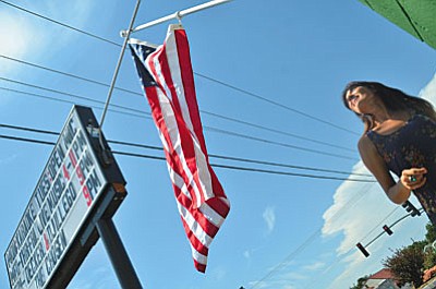 Owner Rebecca Riffel puts up a new flag with her mom at the Main Stage in Cottonwood Wednesday just in time for the Fourth of July. VVN/Vyto Starinskas