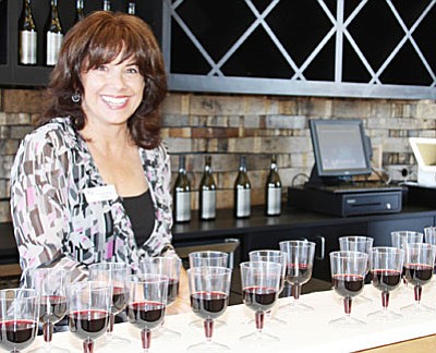 Wine tasting room associate Valerie Wood offers a taste of student-crafted wine at Yavapai College’s new Southwest Wine Center Tasting Room. (Photo courtesy of Yavapai College)