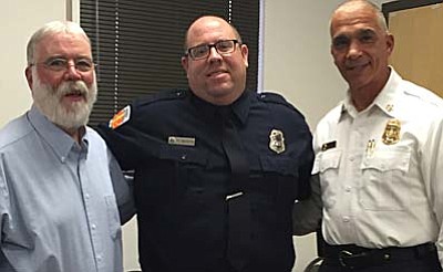 Seth Murphy is congratulated on his promotion to captain by his father, Tom (left), and Verde Valley  Fire District Chief Nazih Hazime.