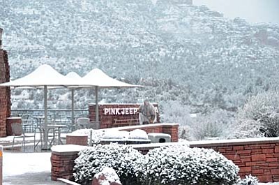 A man clears snow on the deck of Pink Jeep in Uptown Sedona on Wednesday morning as Sedona is hit by a snowstorm. (Photo by Vyto Starinskas)