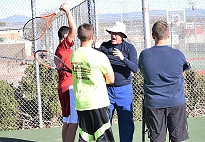 Larry Lineberry (middle) gives serving instruction to some of his players during a preseason practice earlier this year. (Photo by Greg Macafee)