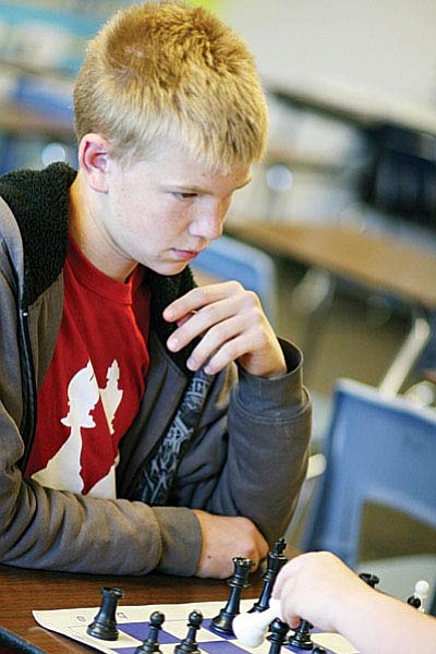 Cottonwood Middle School eighth grader Deion Totten plans his next move against fellow chess club member Angelica Kline. (Photo by Bill Helm)