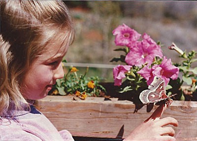 Six-year-old Rosa Sidy, the author’s daughter, enjoying a visitor to her family’s garden.
