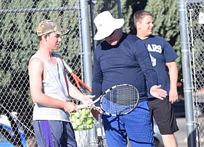 Larry Lineberry, right, teaches one of his Mingus Union tennis players about form during a practice at Mingus Union High School earlier this year. (Photo by Greg Macafee/VVN)