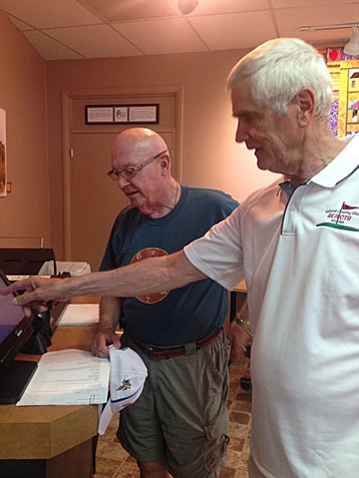 Dale Albright, library volunteer, shows Bruce Vegter how to scan documents using the new Library Document Station at SPL-V.