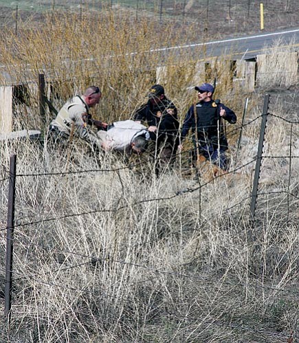 <br>Photo/Chad Hoctor<br>
Law enforcement officials apprehend a man following a train robbery March 26 near Interstate 40 in Williams.