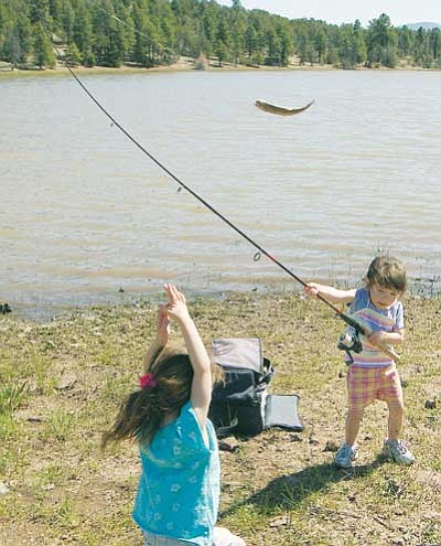 Photo/John Rushton<br>
Riley Rushton catches her first fish as her sister Reece scrambles to get out of the way.