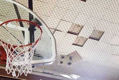 Ceiling tiles rest in netting installed in the Williams High School gym as a safety precaution.