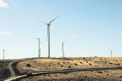 Ryan Williams/WGCN<br>
Trucks pass by wind turbines on Perrin Ranch located 13 miles north of Williams and west of Highway 64.

