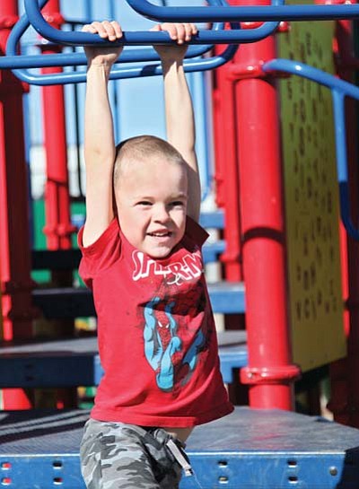 Ryan Williams/WGCN<br>
Six-year-old Evan Breihan swings from the monkey bars last week dressed for warm weather.