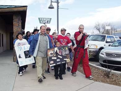 Submitted photo<br>Chandler Plante marches through Camp Verde on Jan. 16. He is holding his MLK poster. Chandler’s father, Robert Plante (left) and big brother Cody Zellner (right) marched with him.