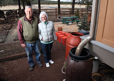 Williams residents Bruce and Linda Carruthers stand next to their rain catching contraption. The Carruthers gathered about 200 gallons of water during rainy weather the weekend of March 1. Ryan Williams/WGCN