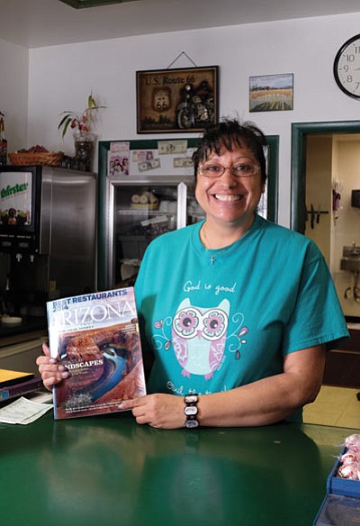 Grand Canyon Coffee and Café owner Anna Dick displays the Arizona Highways edition where her restaurant is featured as one of the Best Restaurants of 2014. Ryan Williams/WGCN