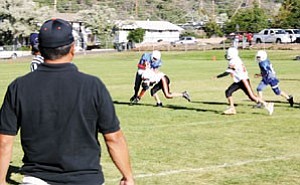 Williams Middle School Falcons Coach Tiger Grantham watches from the side as his team brings down a Camp Verde runner at an earlier season game. The Falcons won Sept. 28 against Shonto.