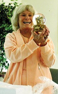Carol Glassburn, chairman of the Williams Needs an Angel Committee, admires a snow globe with an angel inside. The globe is also a music box that plays the song, ³Close to You.² Donna Eastman presented the gift during the retreat, and stated that Glassburn is truly Williams¹ own angel.