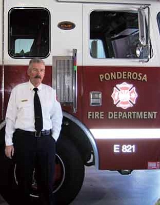 Submitted photo
Ponderosa Fire District Chief Mark Sachara stands next to a fire truck following a badge pinning ceremony Feb. 13 at the Bellemont Fire Station.