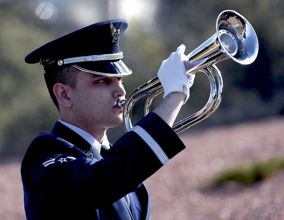 Airman First Class Brennan with the Luke Air Force Base Honor Guard plays taps on a bugle Tuesday morning,  March 1, 2016, at the Prescott National Cemetery during the funeral for Air Force Brigadier General Duane Harold "Leif" Erickson in Prescott.