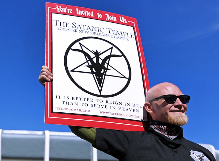 Chris Bridges holds a sign for The Satanic Temple during a Jan. 24, 2015, protest outside of an all-day prayer rally headlined by Louisiana Gov. Bobby Jindal in Baton Rouge. The Phoenix council was poised Wednesday, Feb. 3, to consider whether a group that uses Satan in its name should be allowed to present the opening prayer during a future council meeting. 
