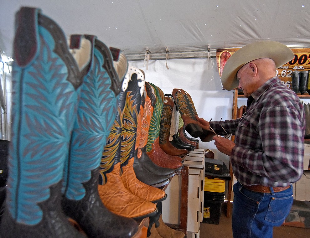Roy Olson of Seligman hunts for a new pair of boots at the Ozuna Boot booth during the Cattleman’s Trade Show Friday afternoon March 18, 2016 during the first day of the 25th Annual Cattleman's Weekend at the Prescott Livestock Auction in Chino Valley. (Matt Hinshaw/The Daily Courier)