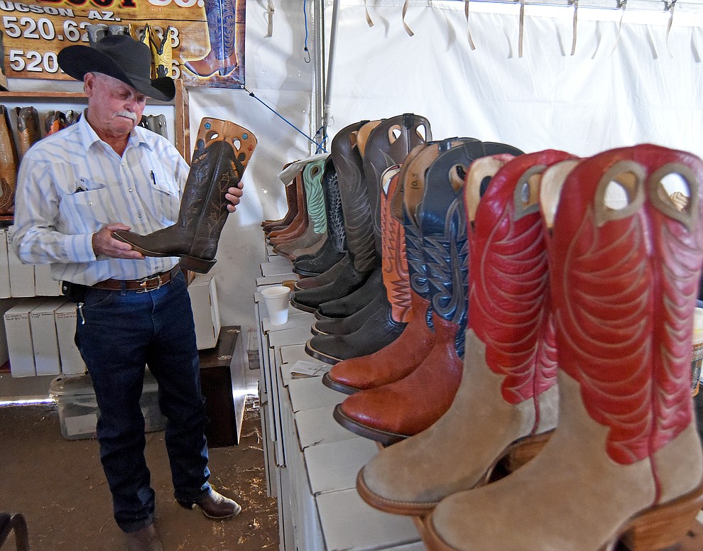 Dick Meyers of Peeples Valley hunts for a new pair of boots at the Ozuna Boot booth during the Cattleman’s Trade Show Friday afternoon March 18, 2016 during the first day of the 25th Annual Cattleman's Weekend at the Prescott Livestock Auction in Chino Valley. (Matt Hinshaw/The Daily Courier)