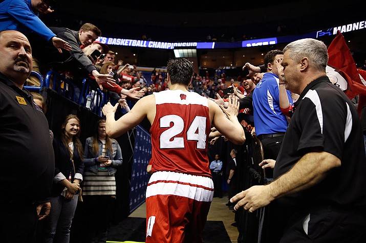 Wisconsin's Bronson Koenig is congratulated by fans as he leaves the court after hitting a three-point basket at the buzzer to defeat Xavier in a second-round men's college basketball game in the NCAA Tournament, Sunday, March 20, in St. Louis. Wisconsin won 66-63. 