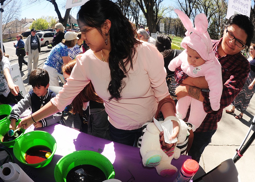 Katrina, Madison (five months) and Lance Dawavendewa color an egg during the Great Prescott Easter Egg Hunt Saturday morning on the Yavapai County Courthouse Plaza.(Les Stukenberg/The Daily Courier)