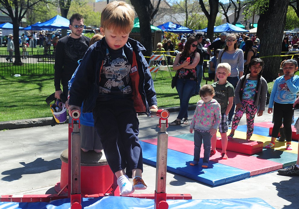 Jonas Parent handles the parrallel bars in the Flip City Gymnastics obstacle course during the Great Prescott Easter Egg Hunt Saturday morning on the Yavapai County Courthouse Plaza.(Les Stukenberg/The Daily Courier)