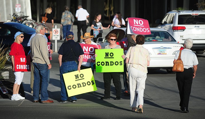 Protesters with signs greeted Prescott Country Club homeowners as they packed the Prescott Valley Town Council Chambers Wednesday night to ask questions about the proposed condominium project in the development. (Les Stukenberg/The Daily Courier)