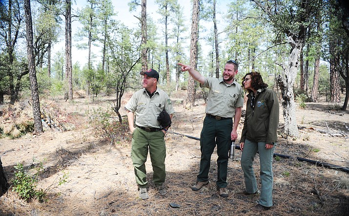 Prescott National Forest officials KC Yowell, Ben De Blois and District Ranger Sarah Tomsky look at a recent hand thinning project during a walking tour during the Joint Chiefs Workshop that  offers info on why PNF burns vs thinning vs mastication; how priority project areas are selected; what role the partners play; what restoration work has been accomplish and what work is planned; and the benefits to our community. (Les Stukenberg/The Daily Courier)