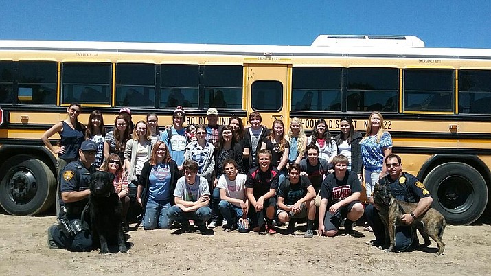 Students going through GEAR UP, a discretionary federal grant program designed to increase the number of low-income students who are prepared to enter and succeed in postsecondary education, pose for a group photo with members of the Prescott Police Department’s K-9 unit after a job shadowing event. 
