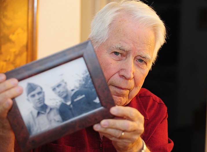 Prescott Valley resident Peter Marshall holds up a photo of his brother and himself taken on the day he came home from being a POW. Marshall, a World War II veteran, was a POW for 1,368 days during the war.