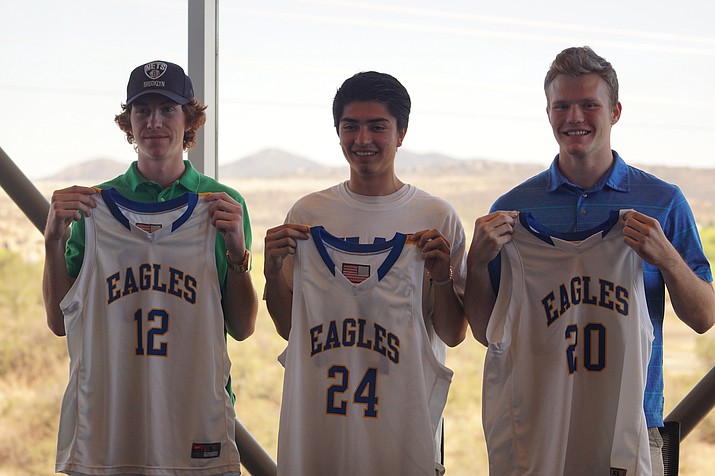 Nick Johnson, left, Gilbert Ibarra, center and Trace Edmier hold up their Eagle basketball jerseys after signing to play for Embry-Riddle on April 5.
