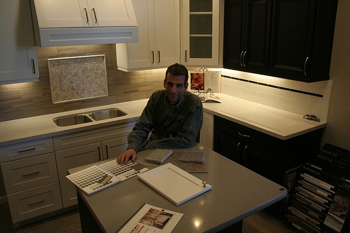 Turk Hartman, owner of Able & Ready Painting – Remodeling, LLC, sits in one of his newly remodeled showrooms. 
