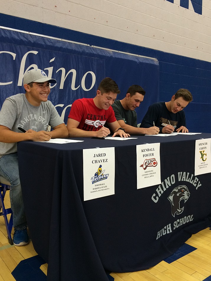 From left, Chino Valley High seniors Jared Chavez, Kendall Foster, Spencer Coffin and Garret King sign letters of intent at the school’s main gym on Wednesday, April 27, to play athletics at separate colleges, starting with the 2016-17 academic year.

