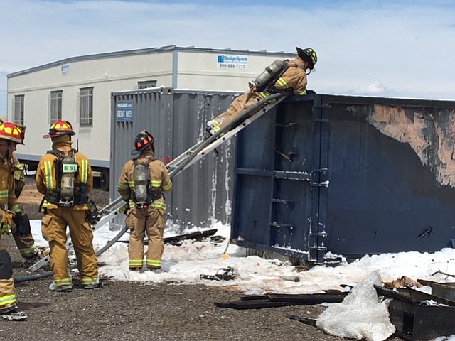 Firefighters check a dumpster near the Prescott airport after it caught fire on April 14. The fire response time took longer than usual, because of a brownout of station 73 at the airport.

