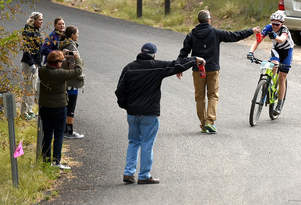 Paul Fabian of Prescott and overall winner of the 30 Proof race grabs a bottle of water from a bystander Saturday morning April 30, 2016 during the 13th Annual Whiskey Off-Road in Prescott. (Matt Hinshaw/The Daily Courier)